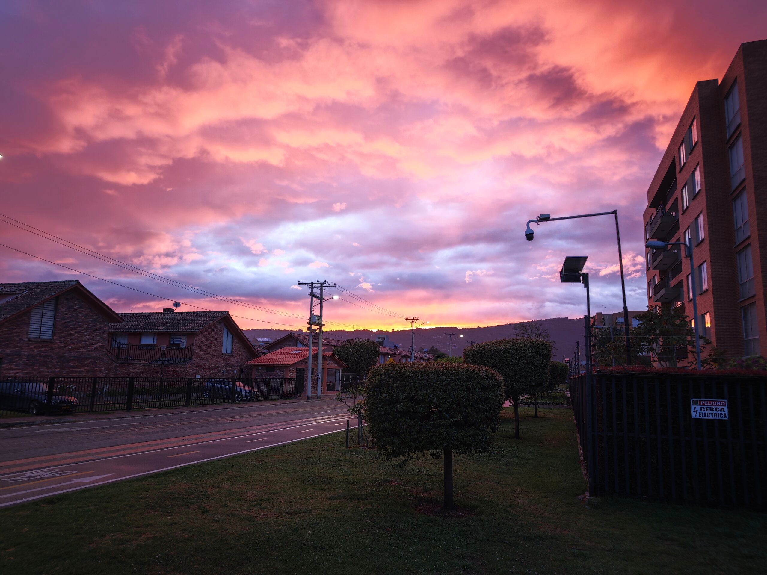 Amanecer rosa y púrpura sobre un barrio colombiano