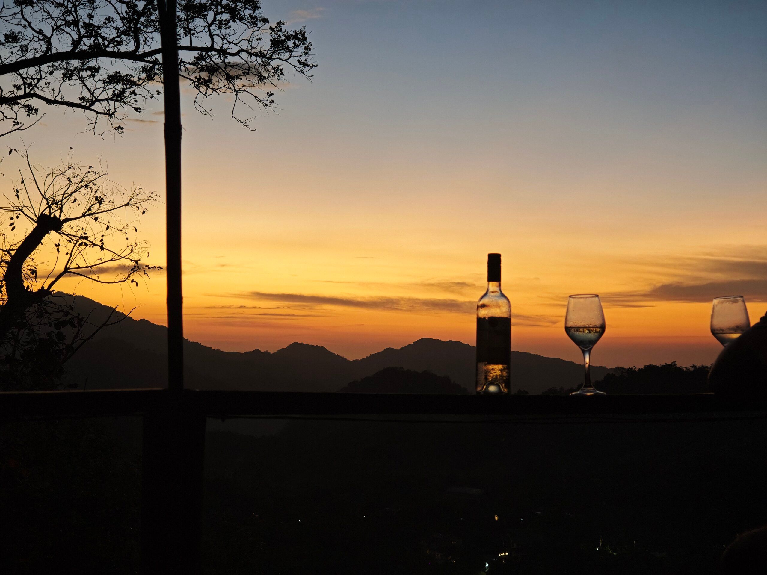Atardecer con copas de vino con vista a las montañas, en Minca, Colombia